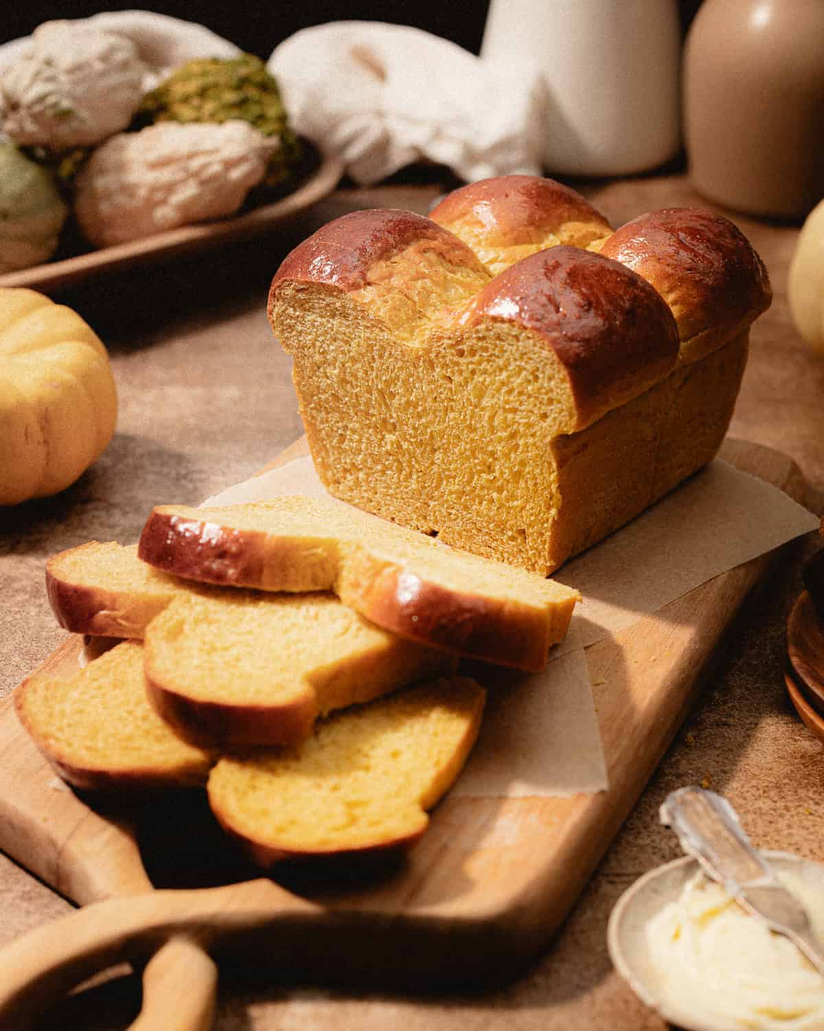 Sliced brioche loaf on a wooden cutting board.