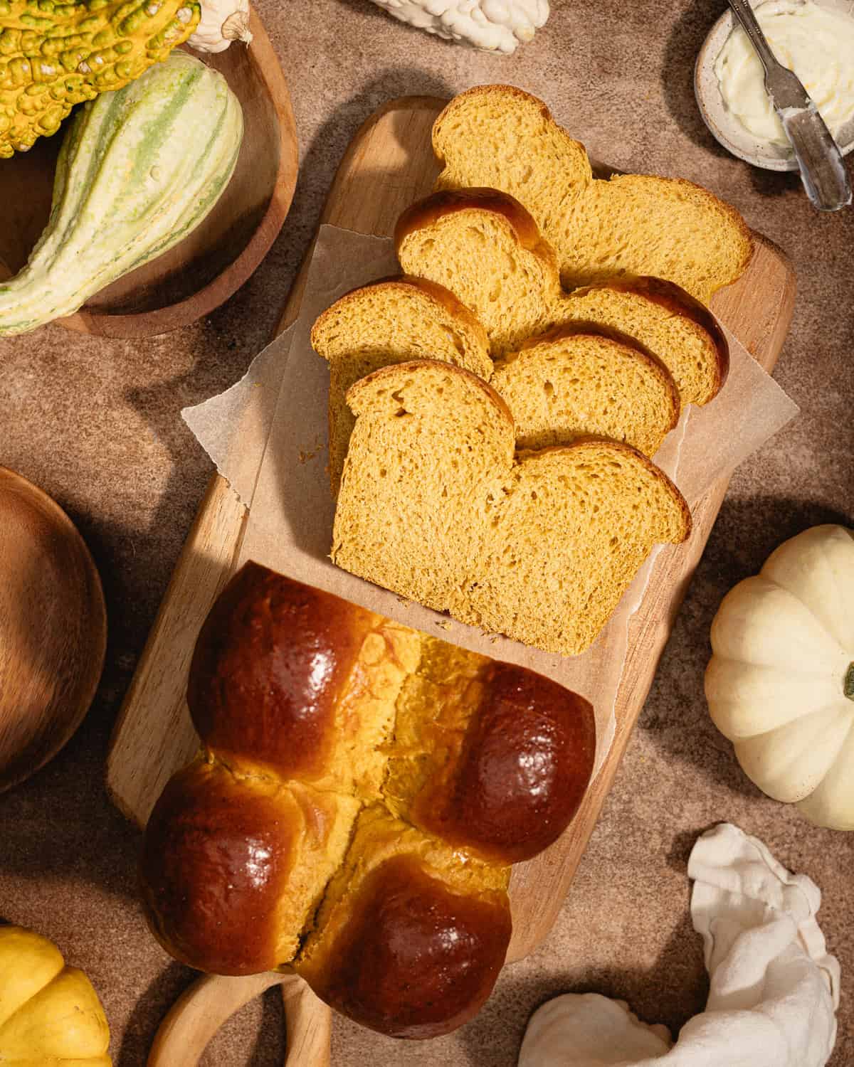 Sliced pumpkin brioche loaf on a cutting board.